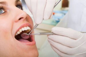 a woman being examined by a dentist