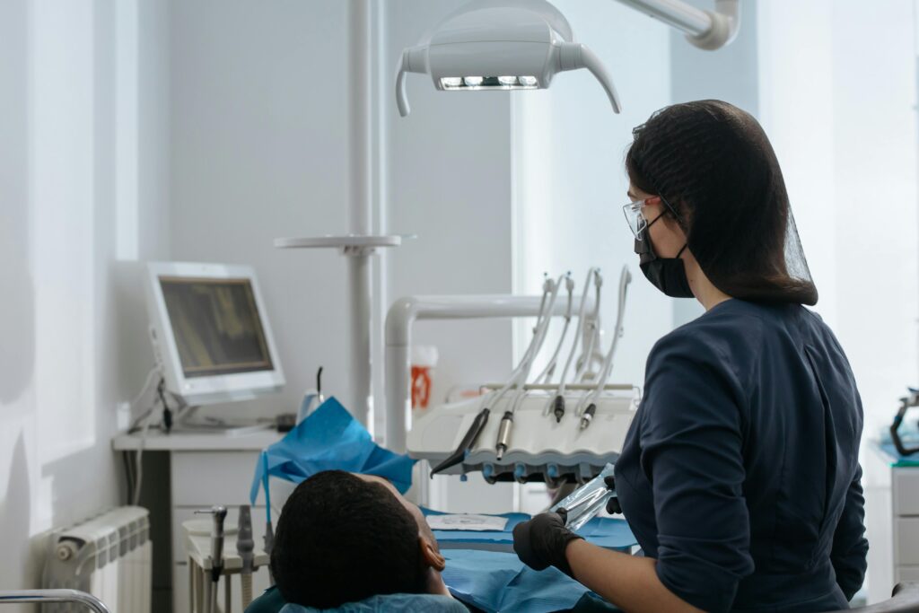 Dental professional preparing for a patient procedure in a modern treatment room.