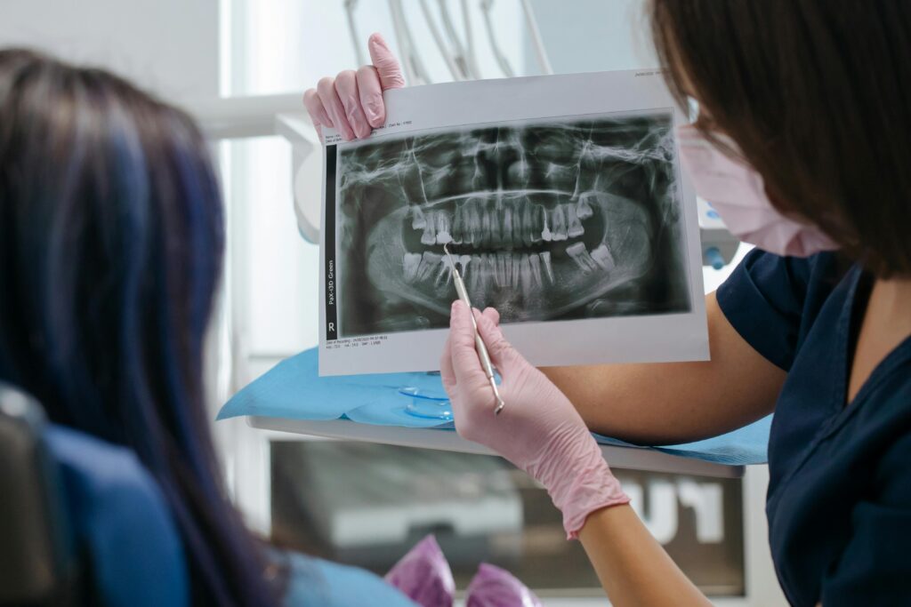 Dental professional reviewing a patient’s panoramic X-ray and explaining treatment options.